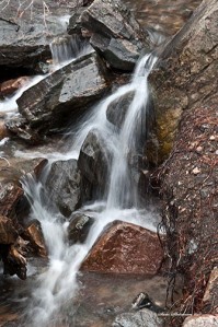 Melting snow creates small streams crashing over rocks and boulders gaining strength, power and freedom.